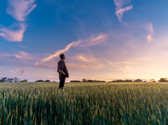 man on grass field looking at sky